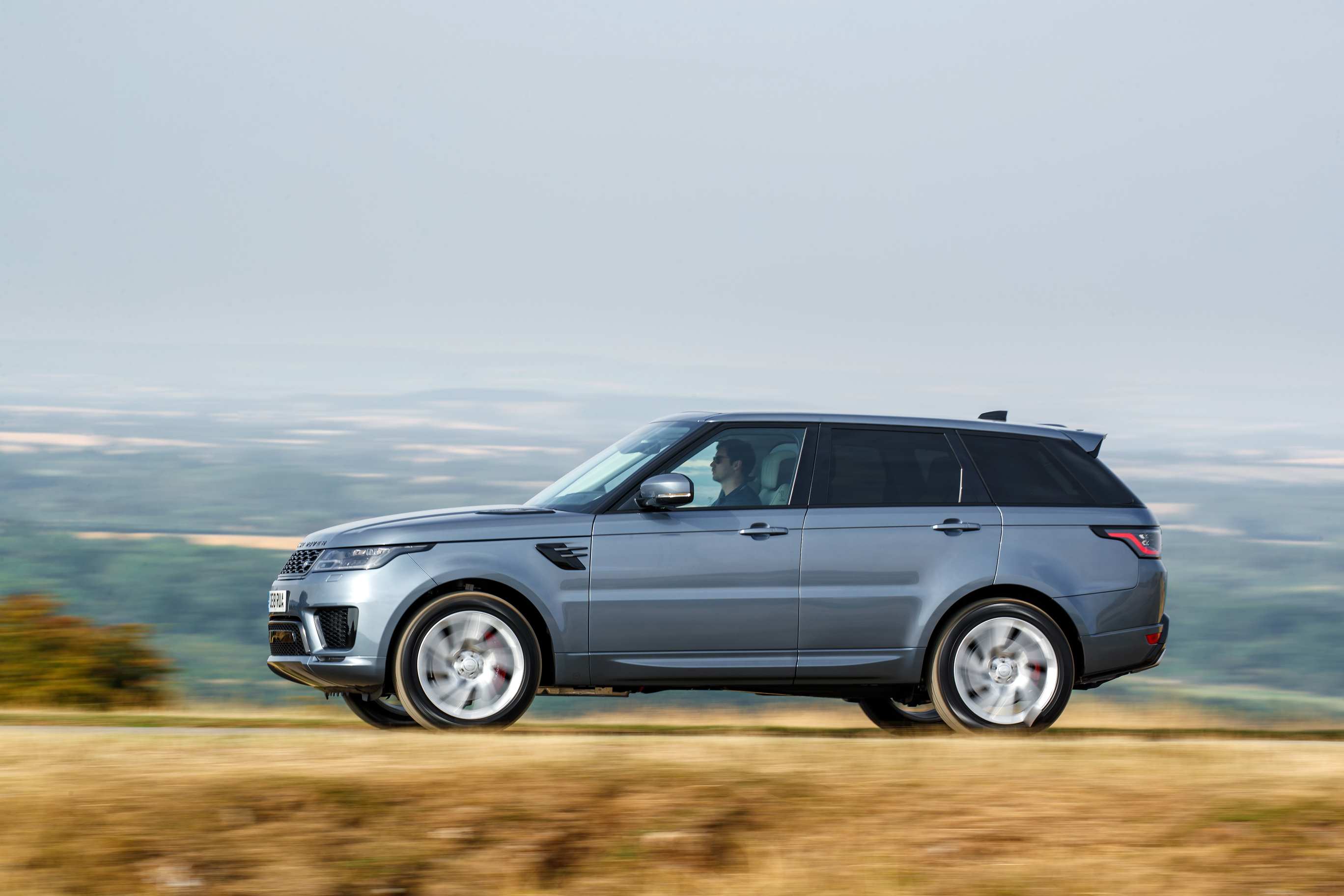 Silver Range Rover Sport p400e driving left side